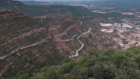 drone reveal shot gliding over green cliffs of grand canyon of spain on tranquil overcast day