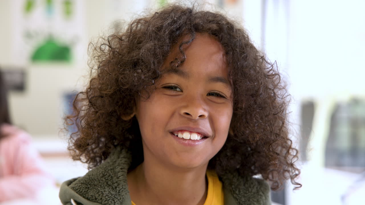 Smiling child in classroom enjoying school day with friends around