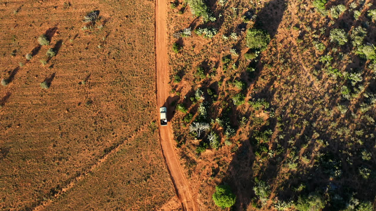 농업 차량이 건조한 먼지 지형을 따라 그의 농지 감시 드라이브를 운전