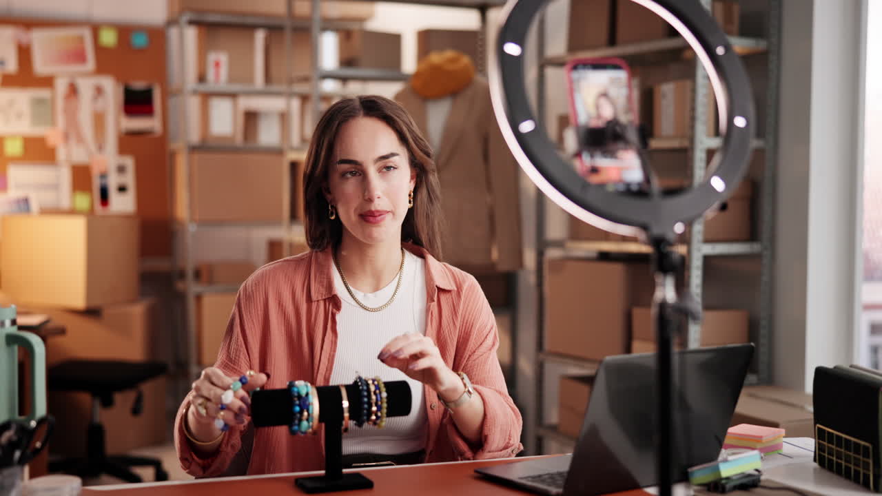 Mujer joven grabando un vlog sobre pulseras para su negocio en línea.