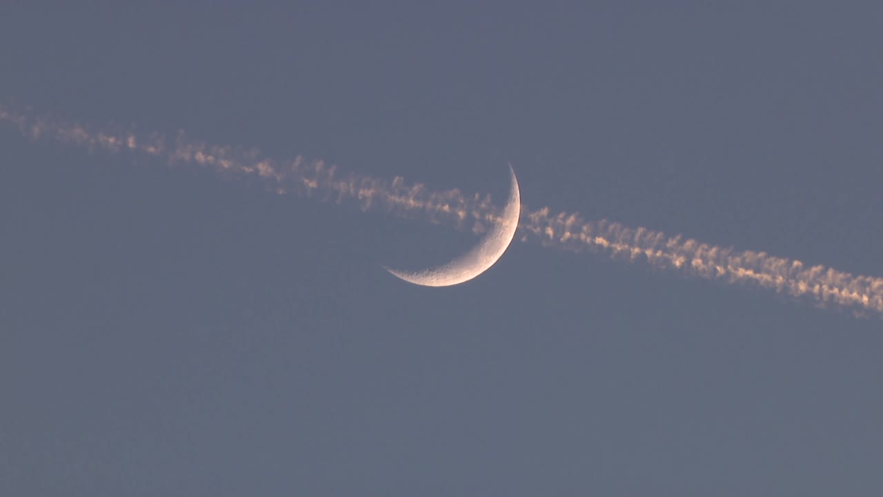 A plane passing by the moon in the night