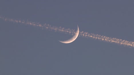 a plane passing by the moon in the night