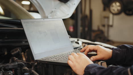 mechanic using laptop for car diagnostics