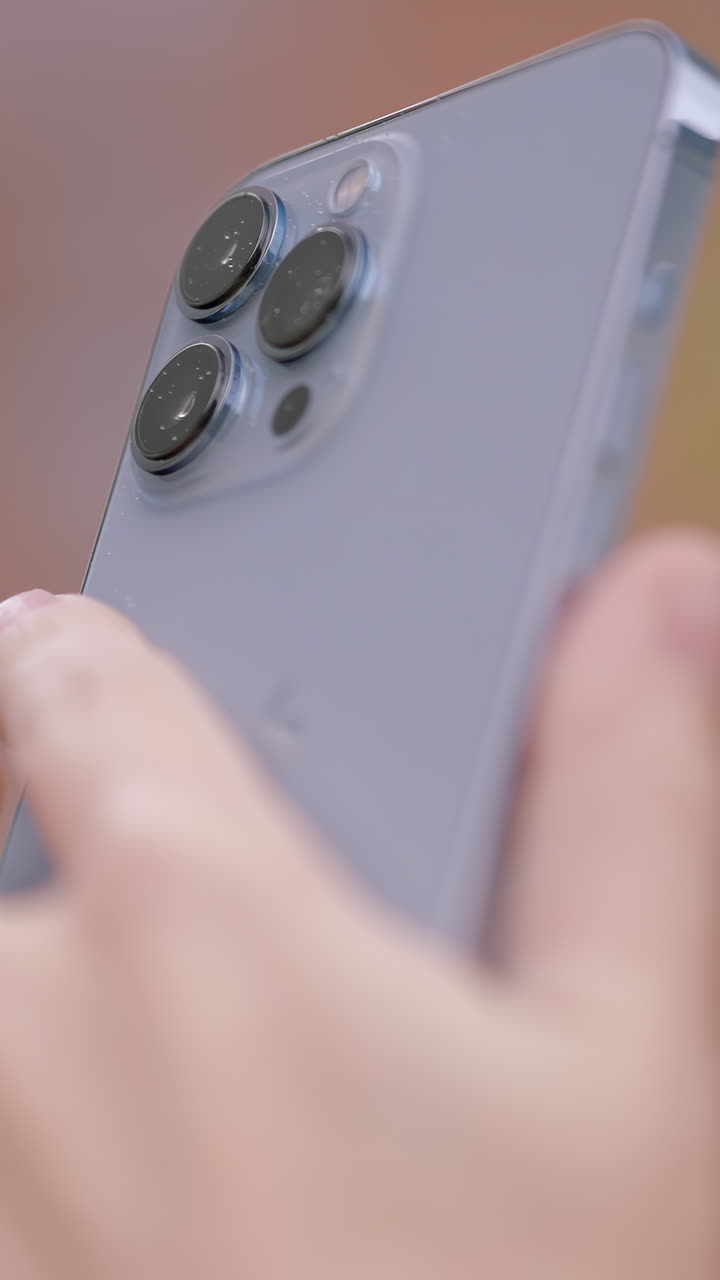 은색 스마트폰을 들고 있는 손