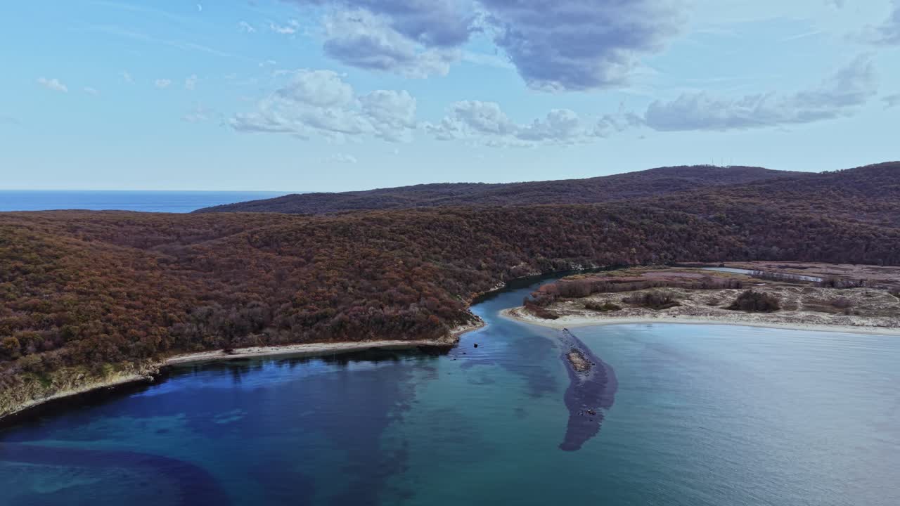 Coastal landscape with river winding through autumn forest