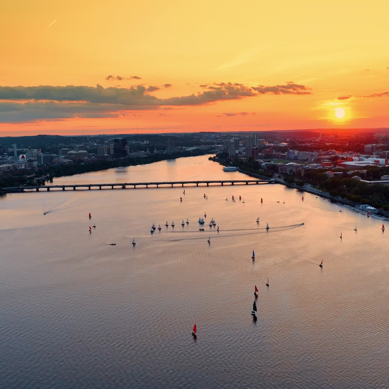 Flying above the Charles River in Boston. Splendid cityscape and waterscape in orange rays of sundown