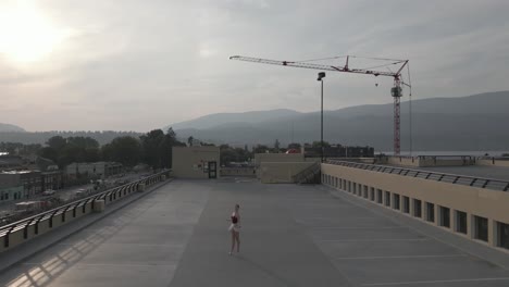 Drone-lifting-up-from-dancer-on-a-parkade-roof