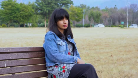 Lonely-girl-sitting-on-a-bench-in-the-park