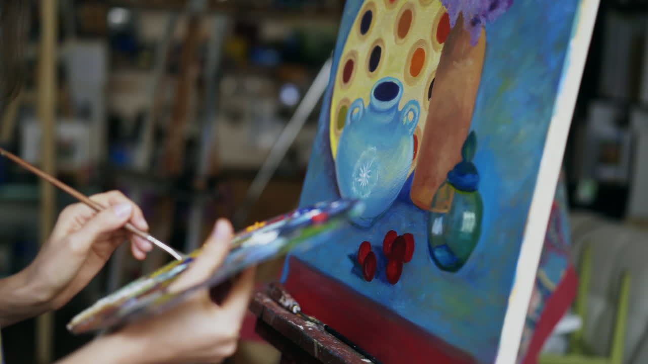 Mujer pintando un bodegón en un estudio de arte