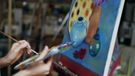 woman painting a still life in an art studio