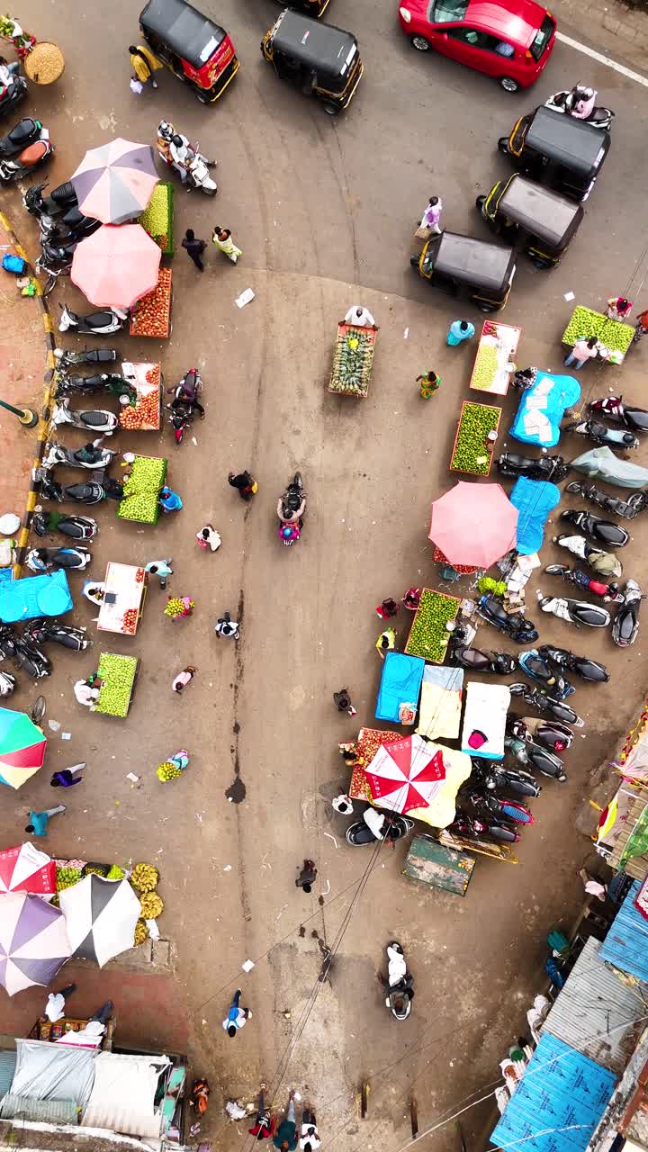 Vertical drone shot of a bustling market street in Mysuru, India, viewed from above.