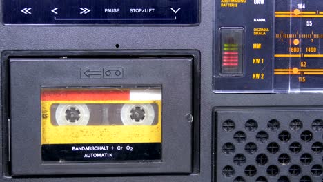 the vintage yellow audio cassette in the old tape recorder rotates