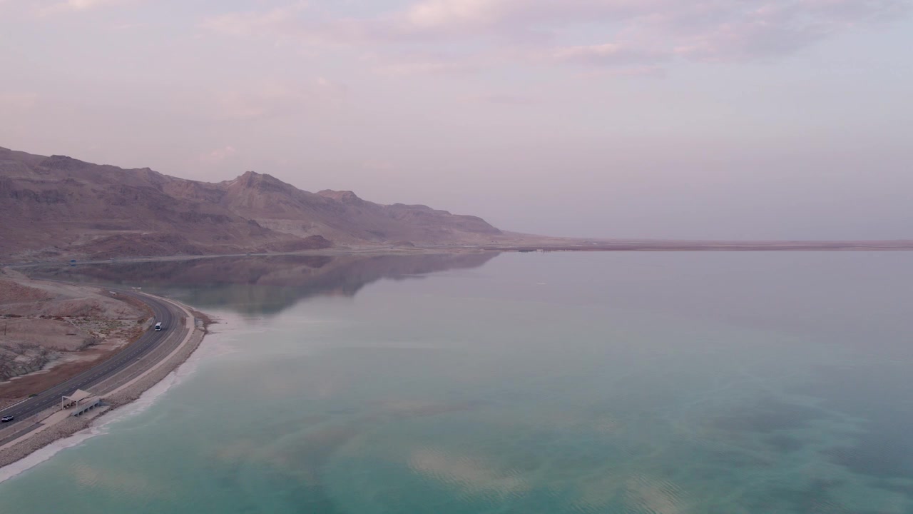 Vista aerea della costa del Mar Morto con acqua turchese e montagne desertiche all'alba