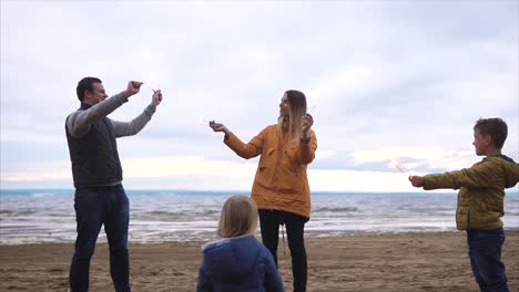family celebrating at the beach with sparklers