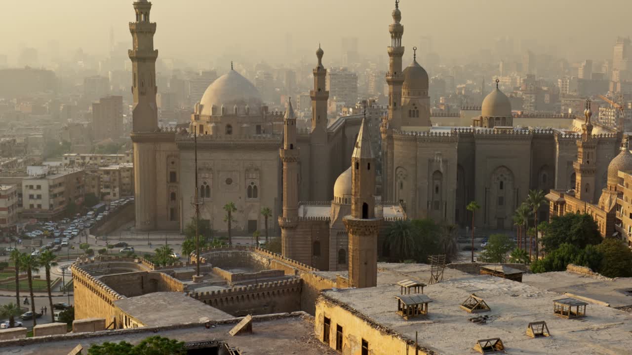 tilt shot de la mezquita del sultán hassan, el cairo, egipto al atardecer. una de las mejores vistas de la ciudad de el cairo - casas, mezquitas y carreteras con vehículos