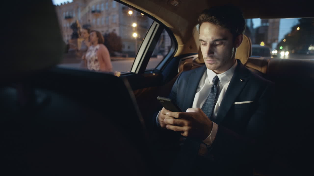 Homem de negócios escrevendo mensagem no smartphone no carro. Homem digitando texto no celular.