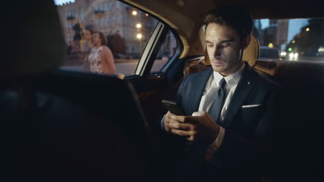 hombre de negocios escribiendo un mensaje en un teléfono inteligente en el coche. hombre escribiendo texto en el móvil