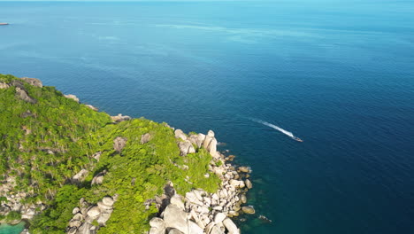 Aerial-of-ferry-boat-vessel-overtaking-corner-of-cliffy-coast-of-koh-tao-Thailand-south-est-asia-famous-travel-destination-for-scuba-diving-course