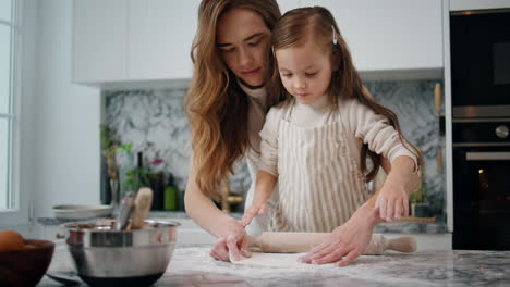 involved family making dough at home close up. tender mother helping child