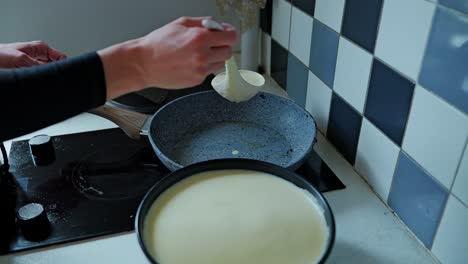 ladle pouring batter onto hot pan, cozy blue-tiled kitchen for morning pancakes