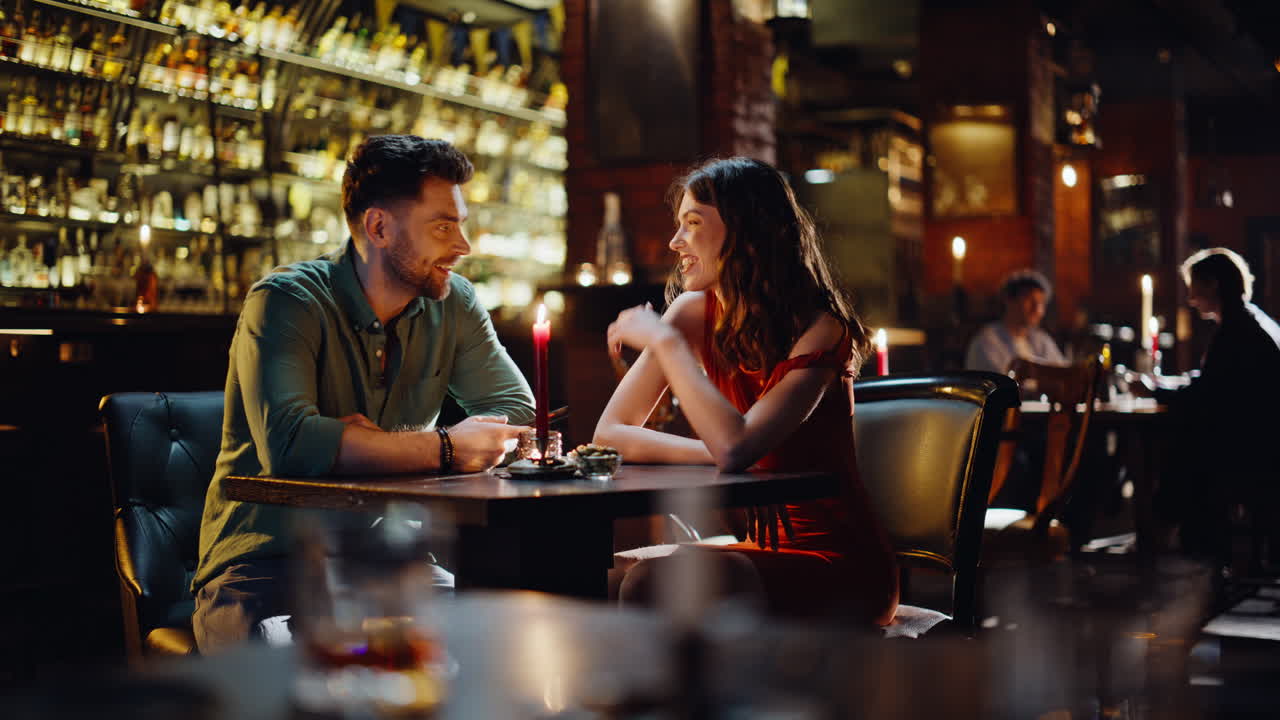 Coppia sorridente che si frequenta in un pub trascorrendo un fine settimana insieme. Coppia felice che parla.