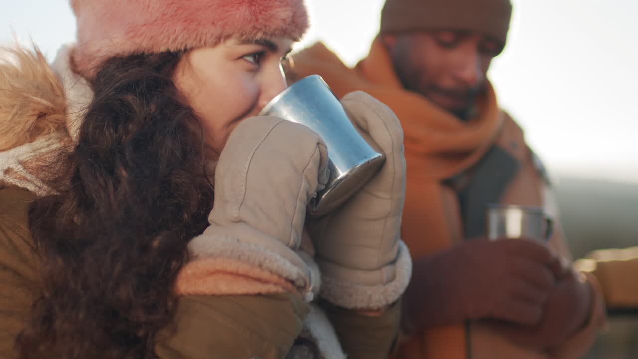 pareja disfrutando de bebidas calientes al aire libre en invierno