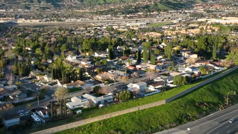 aerial view of santa clarita residential community, homes by interstate freeway on sunny evening