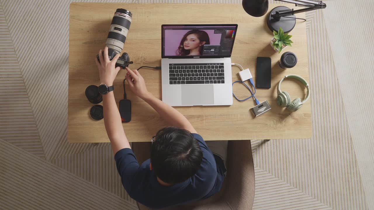 Top View Of A Male Editor Putting The Memory Card On A Laptop To Choose The Photos While Editing Them In The Workspace At Home
