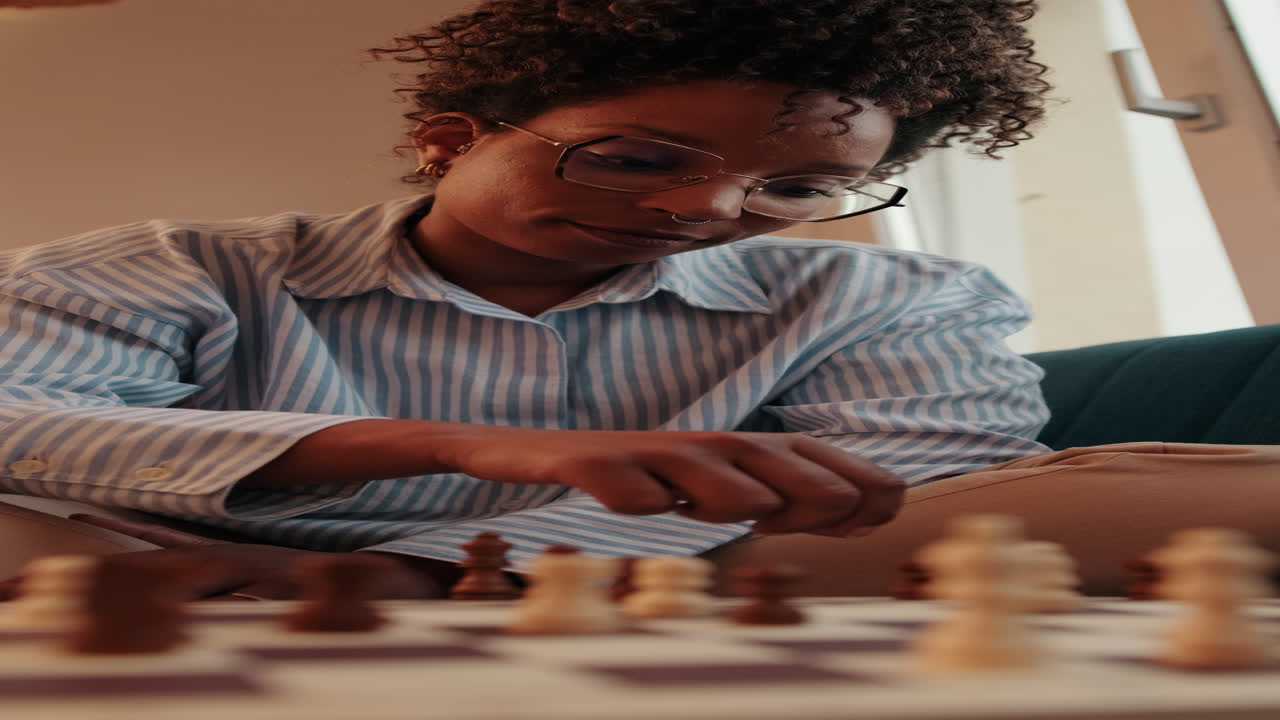 Person Playing Chess and Moving Knight Piece