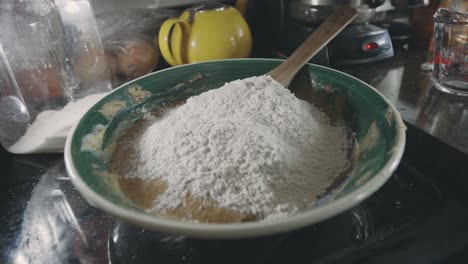 adding flour to cookie dough mixture in the kitchen - close up