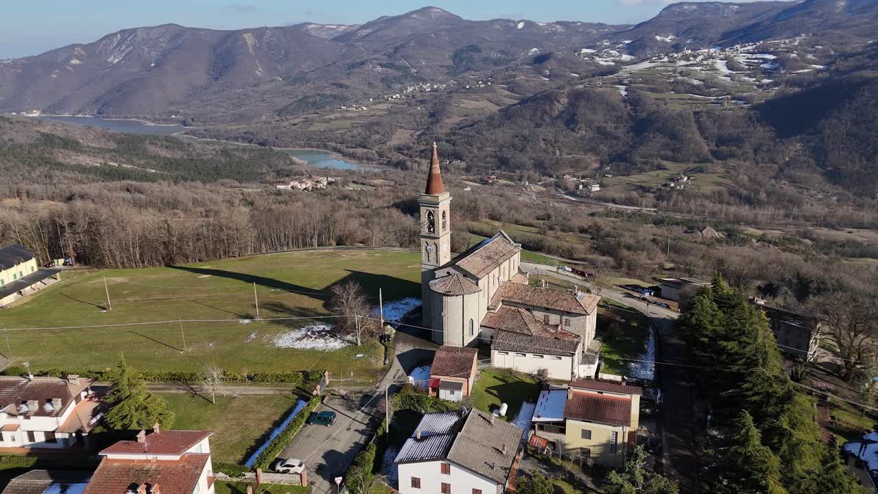 La Chiesa dei Santi Salvatore e Gallo si trova a I Rabbini, Morfasso, con la sua facciata in pietra e il campanile incorniciati dalle case del borgo e dall'osteria Pie di Monte.