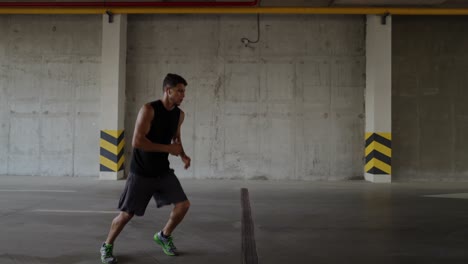 Athlete-in-sportswear-warms-up-on-a-city-parking-garage,-accelerate-footage