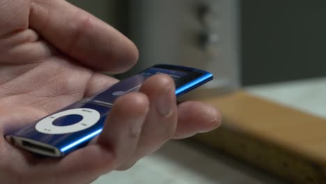 person holding a vintage blue ipod