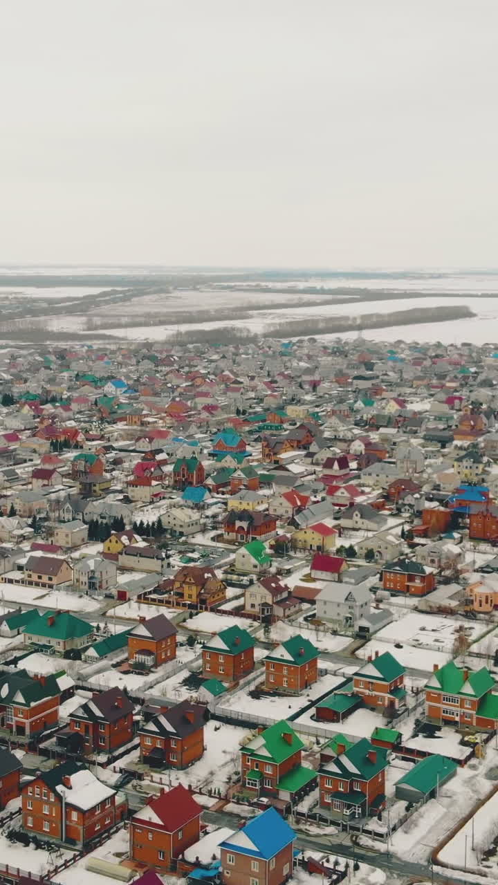 neatly designed residential cottage complex with great infrastructure against snowy fields bird flight view