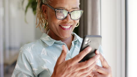 Mujer-Mayor-Afroamericana-Sosteniendo-Un-Teléfono-Inteligente,-Sonriendo