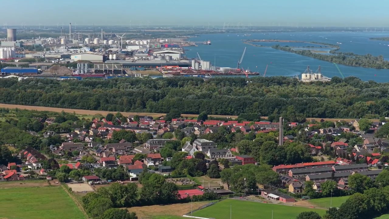 Flygfoto över bostadsområde nära industrihamn och flod