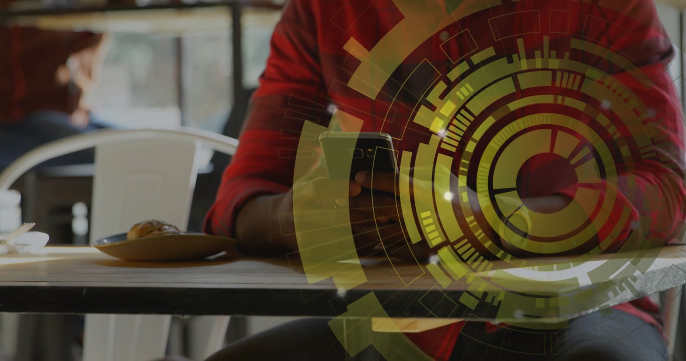 Man sitting at cafe table holding smartphone tapping screen, tap starting yellow HUD showing data