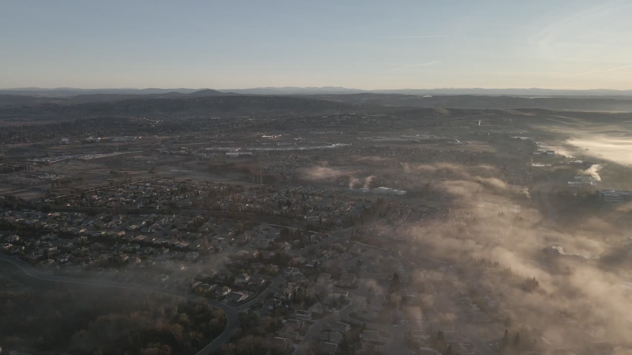 Wide angle drone footage over Folsom, USA on a bright early morning, with misty clouds moving in from the right