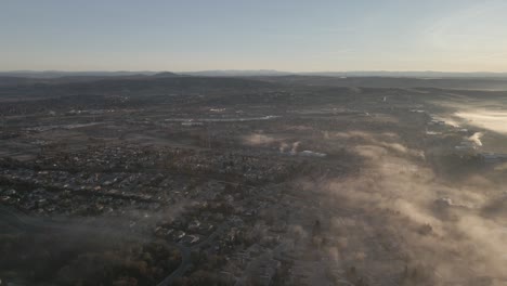 wide angle drone footage over folsom, usa on a bright early morning, with misty clouds moving in from the right