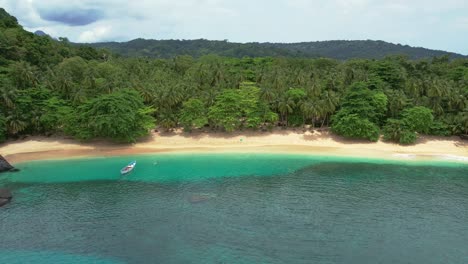 Aerial-view-of-boat-floating-on-turquoise-colored-waters-from-Principe-Island