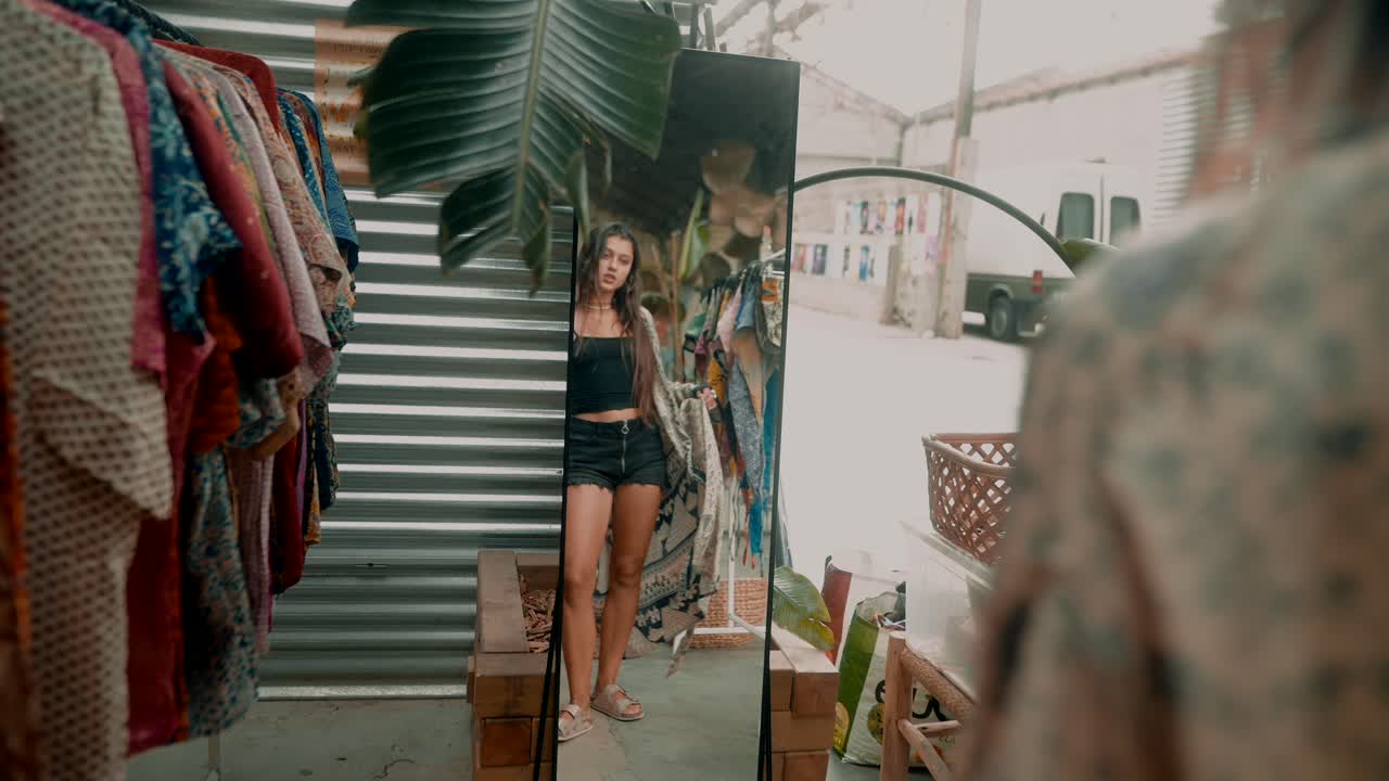 Fashionable woman in retail shop looking in mirror