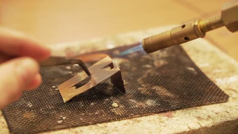 Soldering-metal-plates-with-butane-gas-flame-burner---close-up-shot-in-slow-motion