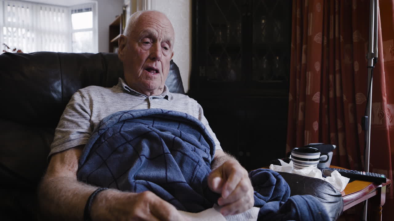 Elderly man with a cold sitting in a chair