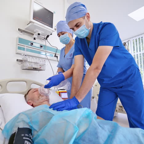 doctor and a nurse give resuscitation to a male patient in the emergency room. cardiac massage. defibrillation.