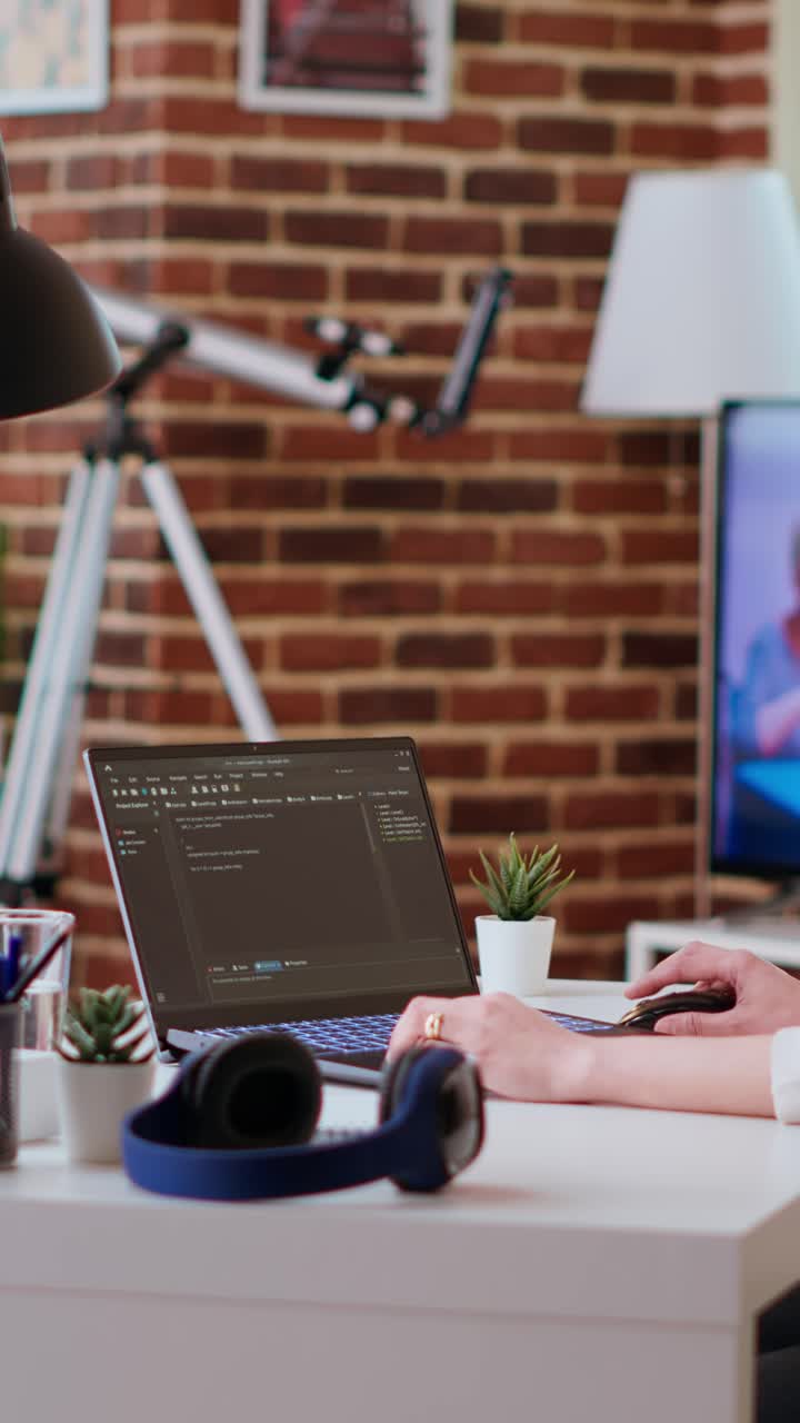 Softwareudvikler, der koder vertikal video i et hyggeligt hjemmekontor