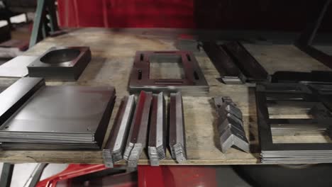 sheets and parts of metal pieces precut with laser, stored on a shelf in workshop