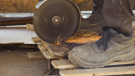 Man-Cutting-Metal-Wires-with-a-Circular-Saw,-Slowmotion,-Close-Up