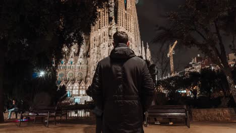 tourist appreciation of the sagrada familia at night in barcelona.