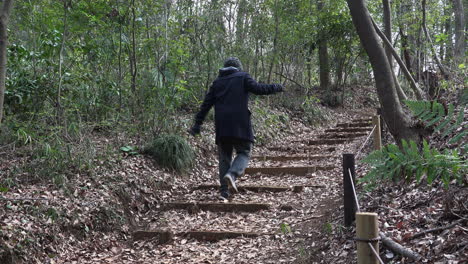 A-man-is-climbing-a-park-stairway-holding-something-in-his-hands-on-a-daytime