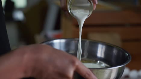 leche sacada de un frasco de vidrio en un cuenco de nieve, filmada como una toma en cámara lenta de primer plano